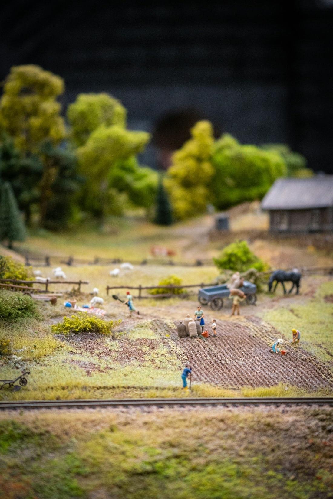 a model of a farm with horses and people