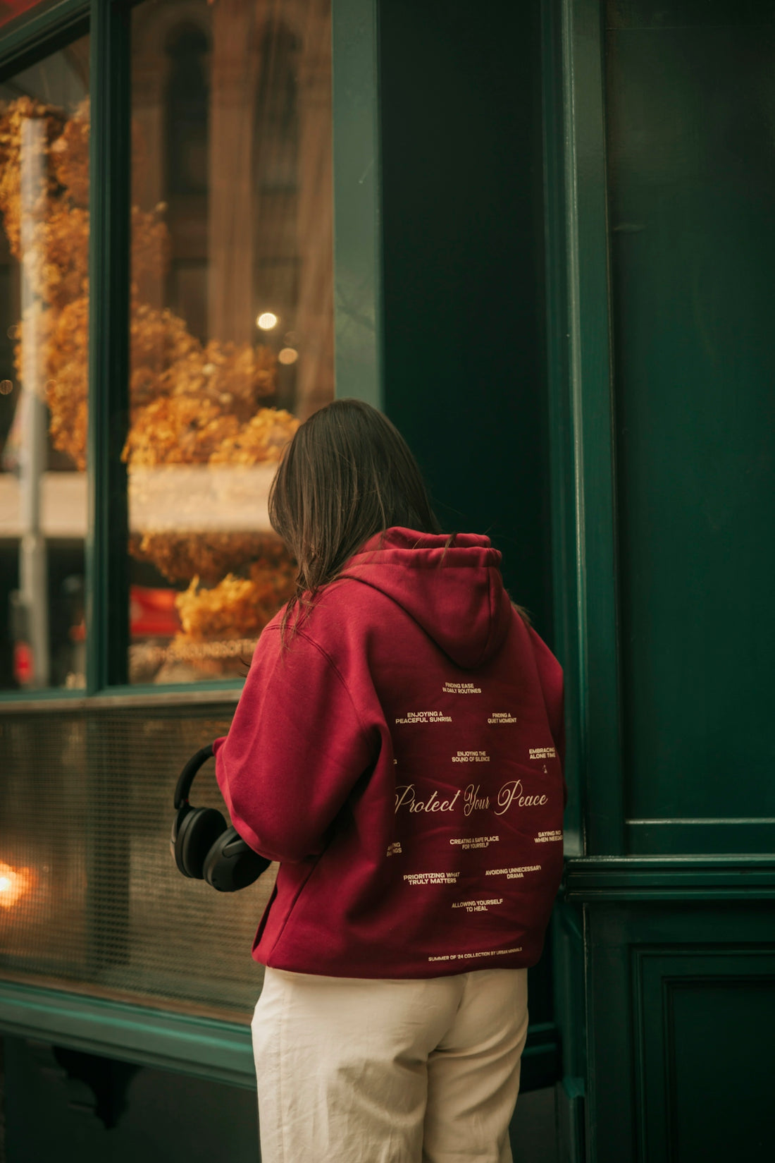 A woman standing in front of a store window