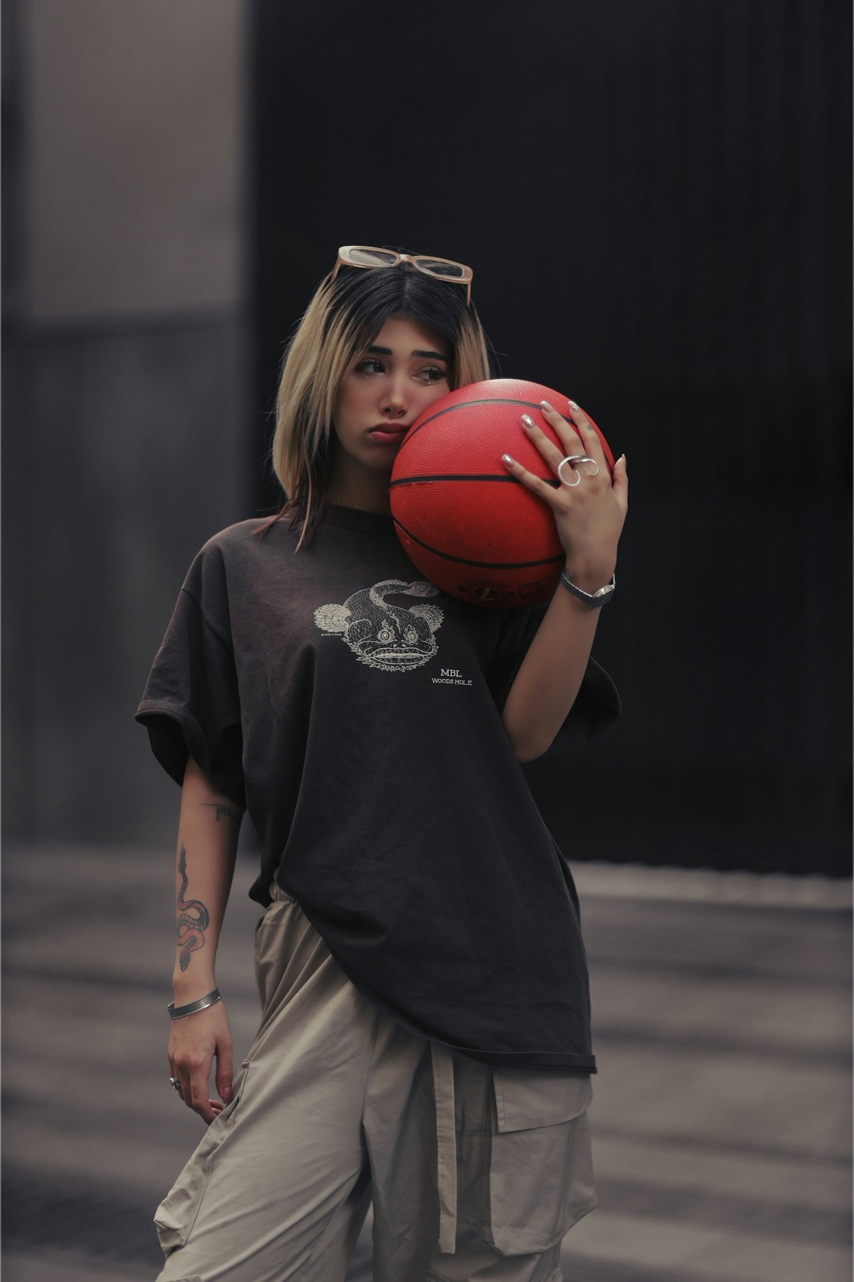 Young woman holding a basketball with a pout